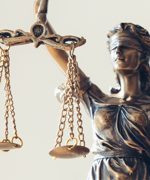 Statue of Themis, the goddess of justice, with a blindfold over her eyes and holding a scale with her right arm.
